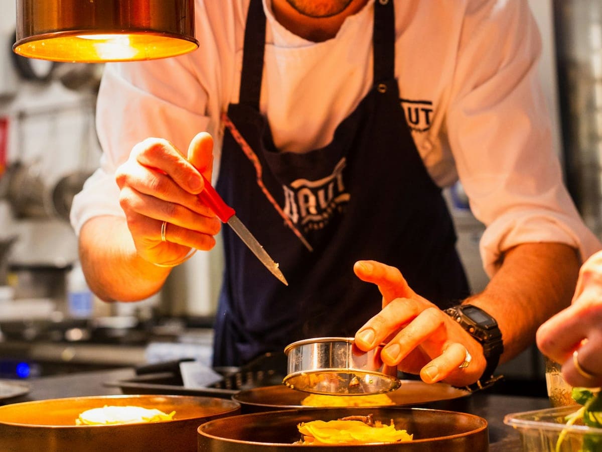 Lo chef impiatta un piatto con le pinzette